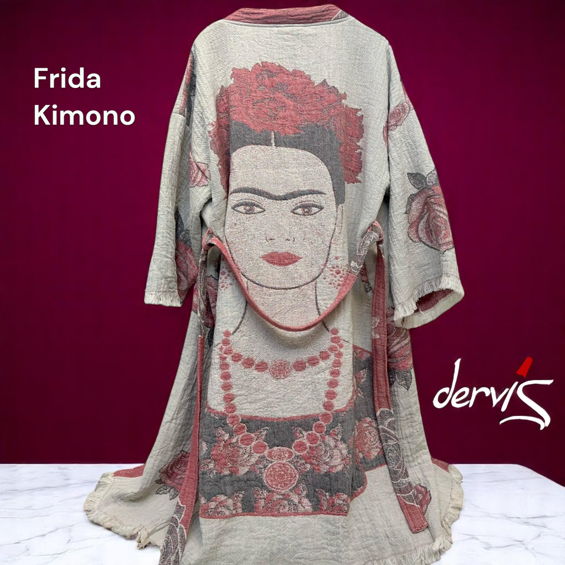 A kimono robe featuring a printed design with a central face motif on a purple background, labeled 'Frida Kimono' by Dervis.