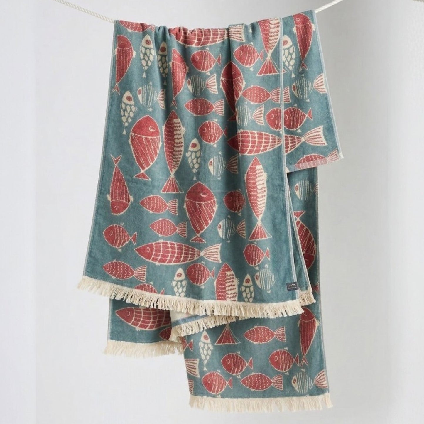 Fish Pattern 3-Layer Turkish Towel – Jacquard Woven Muslin Beach Towel hanging on a line against a white background
