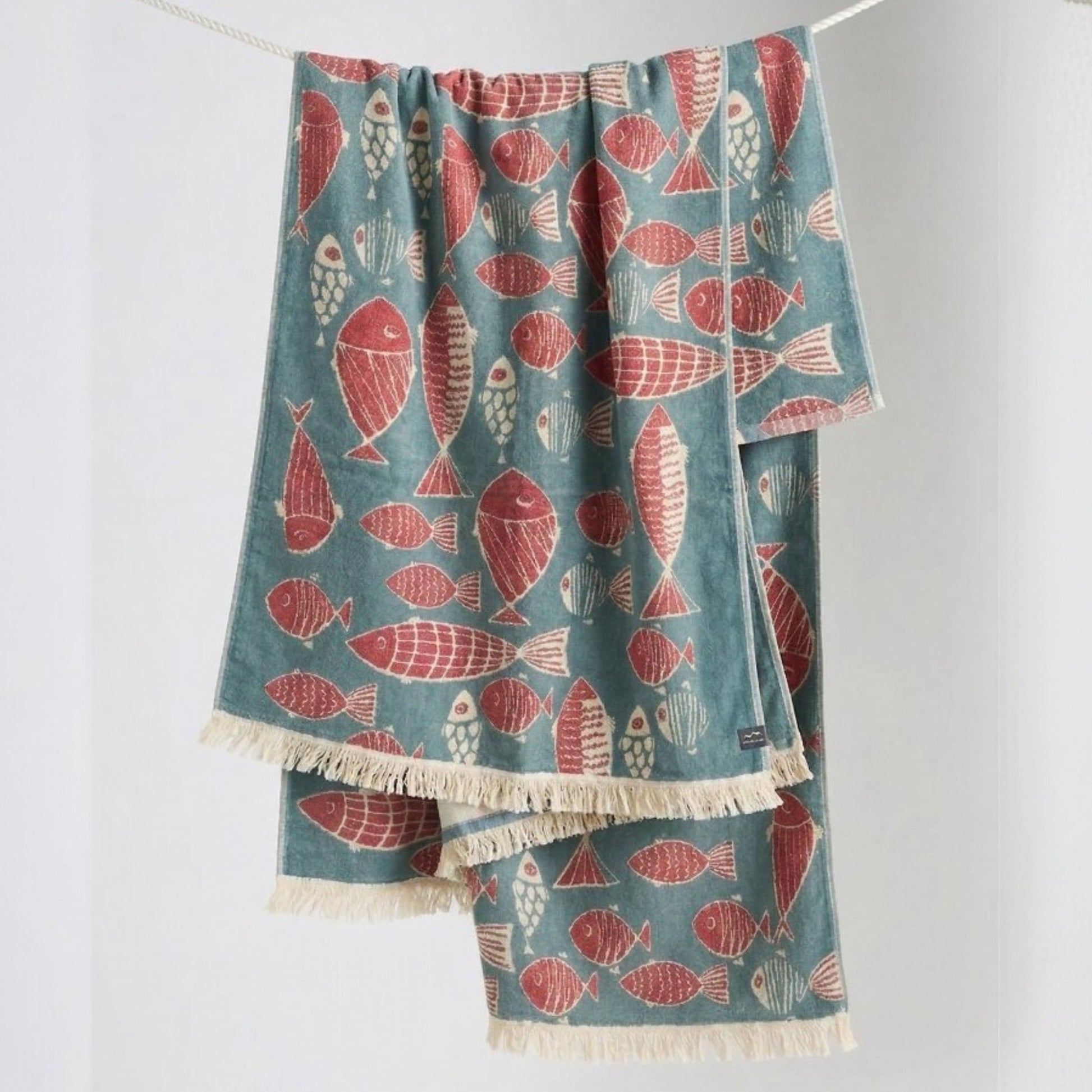Fish Pattern 3-Layer Turkish Towel – Jacquard Woven Muslin Beach Towel hanging on a line against a white background