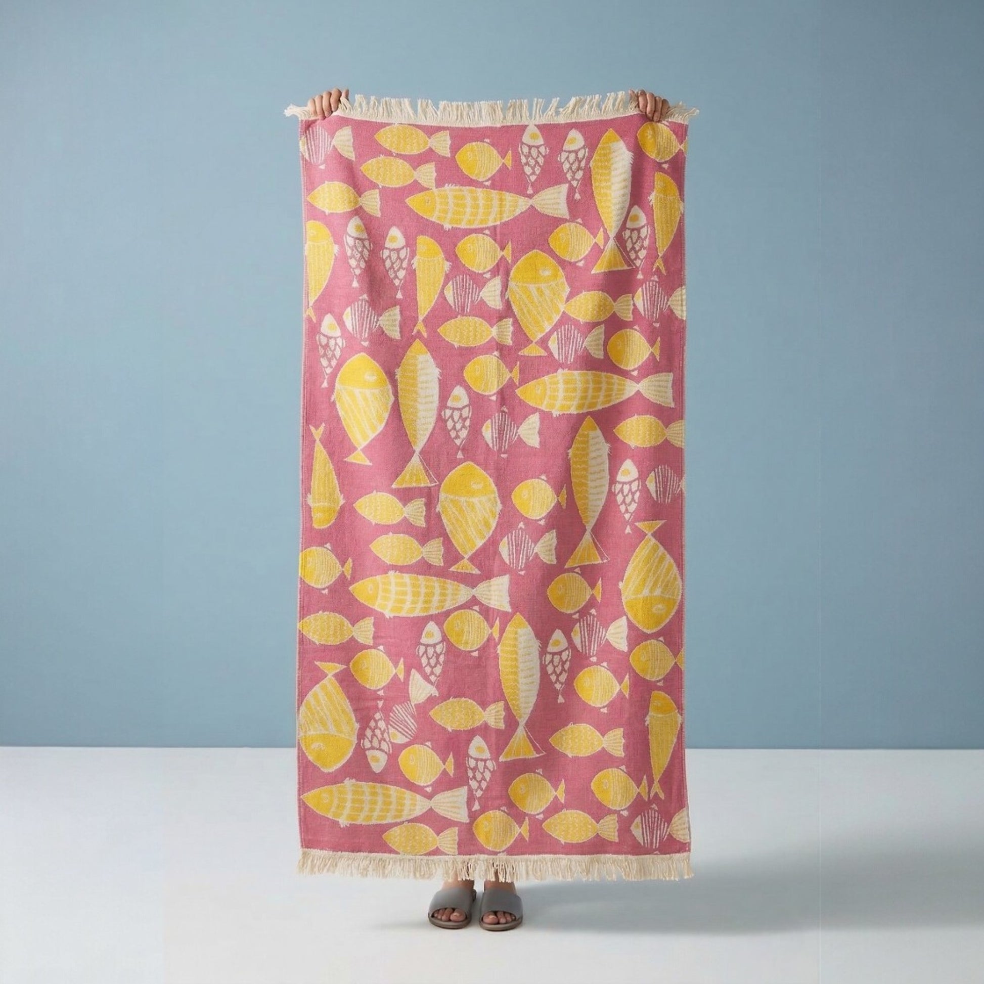 Pink Fish Pattern 3-Layer Turkish Towel – Jacquard Woven Muslin Beach Towel on a light blue background