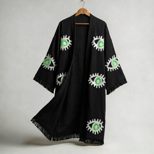 hand woven evil eye turkish cotton kimono robe black on a hanger against a gray background