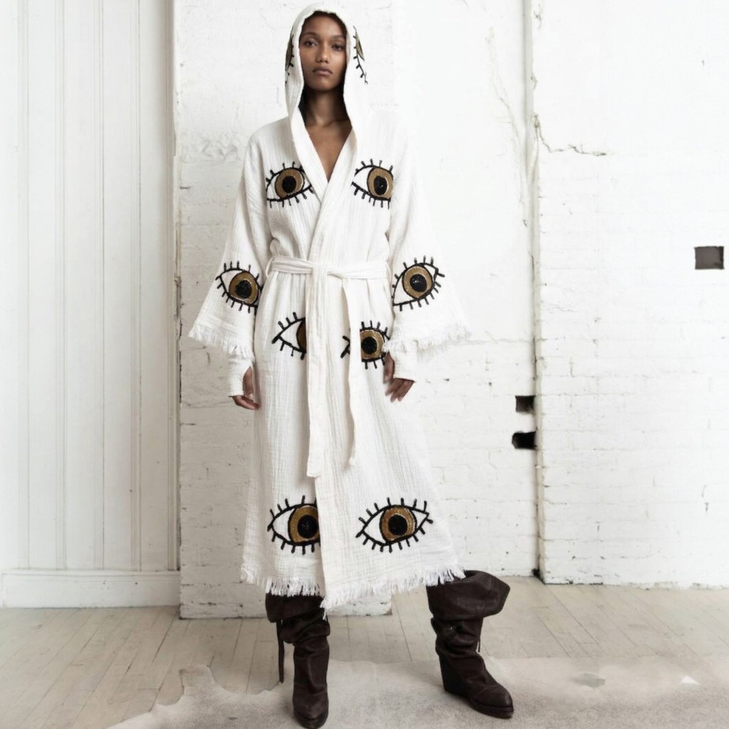 Person wearing a Hooded Turkish Towel Kimono Robe – Handwoven Muslin Cotton, Brown Evil Eye Design in a minimalistic setting